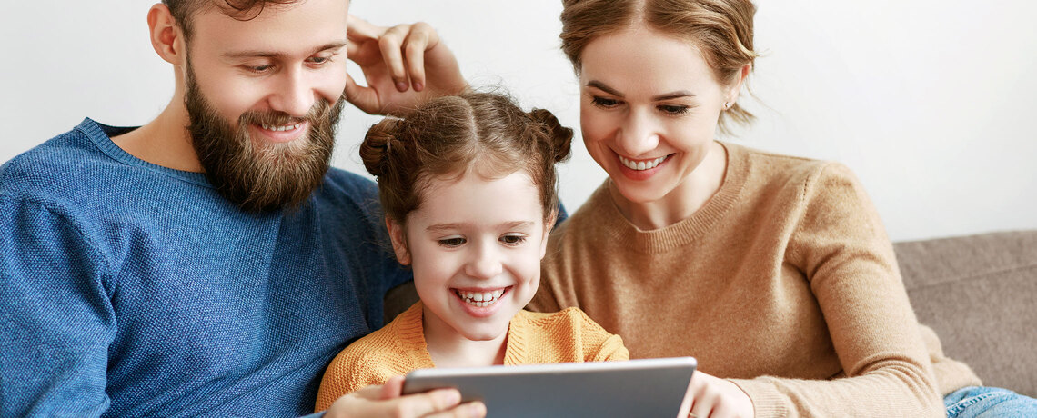 Eltern lesen mit ihrem Kind die digitale Tageszeitung